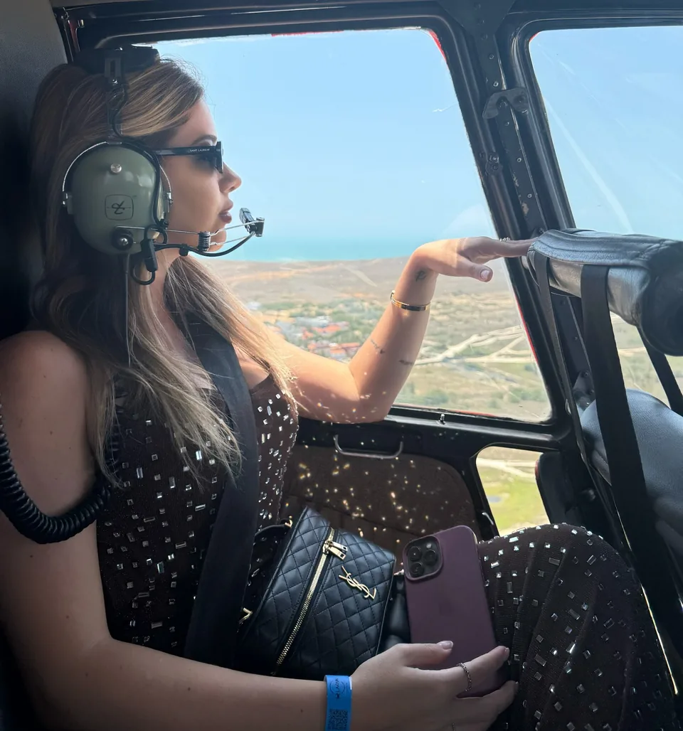 Mirella Sordi com fone de aviação na cabine de um helicóptero